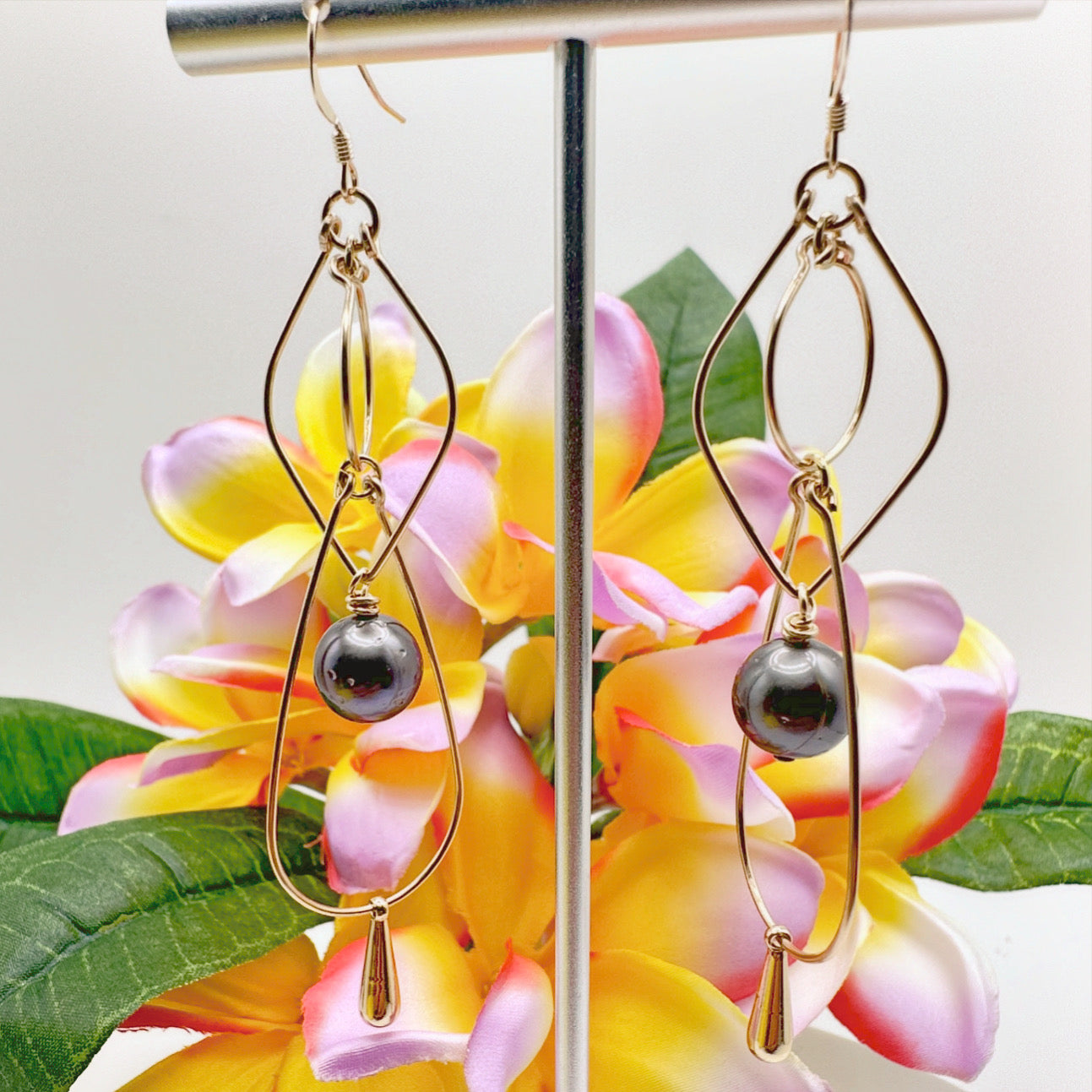 Introducing the epitome of elegance - these triple drop hoop earrings crafted with 14kt gold filled hoops, embellished with exquisite Tahitian pearls, and delicately balanced with a gold filled droplet. The combination of the lustrous pearls and the radia